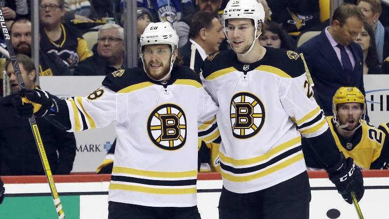 Boston Bruins right wing David Pastrnak (left) and defenseman Brandon Carlo (right)