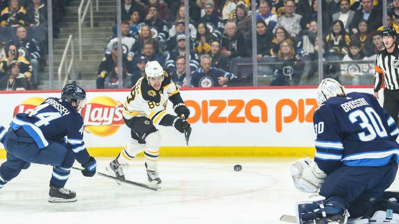 Boston Bruins forward David Pastrnak (88) and Winnipeg Jets goaltender Laurent Brossoit (30)