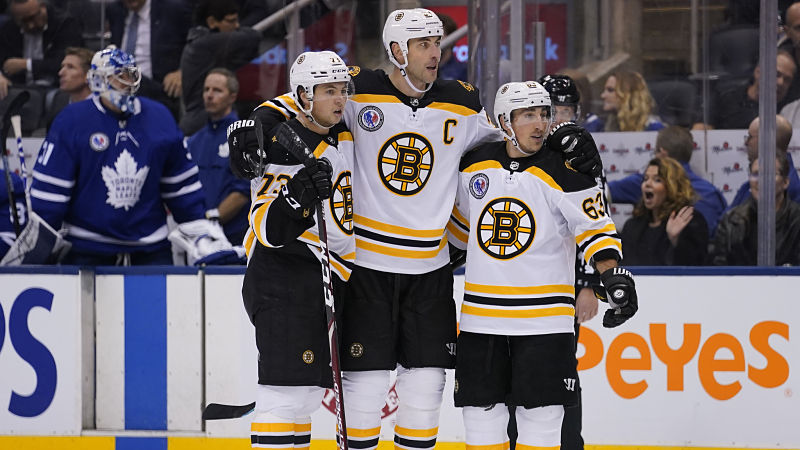 Boston Bruins defensemen Charlie McAvoy and Zdeno Chara and forward Brad Marchand