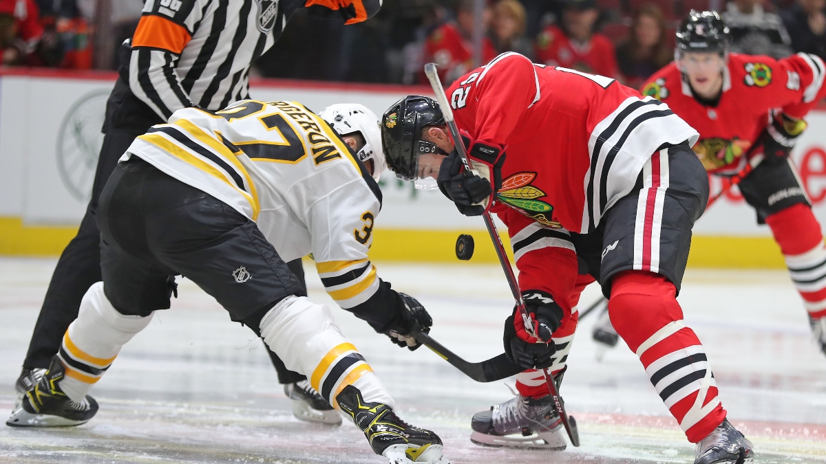 Chicago Blackhawks center Ryan Carpenter (22) and Boston Bruins center Patrice Bergeron (37)