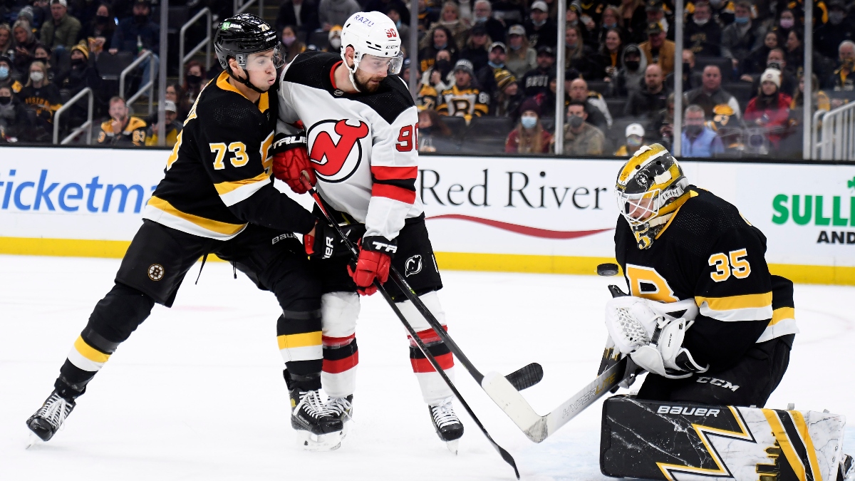 Boston Bruins goaltender Linus Ullmark (35), defenseman Charlie McAvoy (73) and New Jersey Devils left wing Tomas Tatar (90)