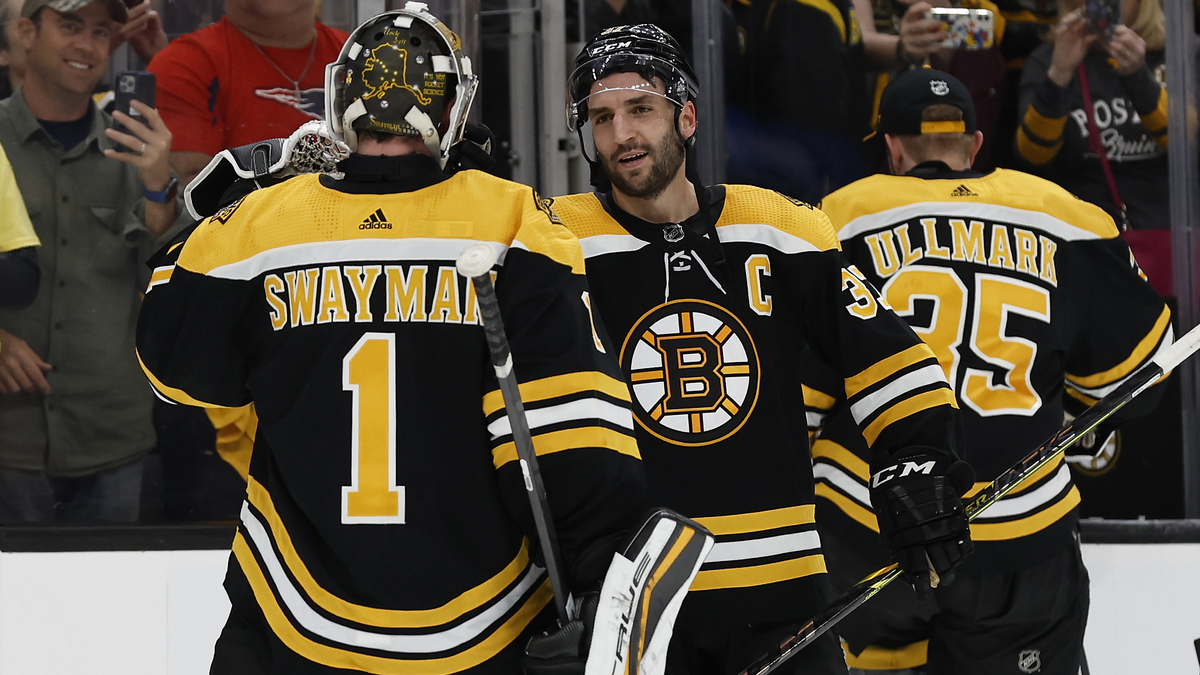 Boston Bruins goalie Jeremy Swayman, center Patrice Bergeron
